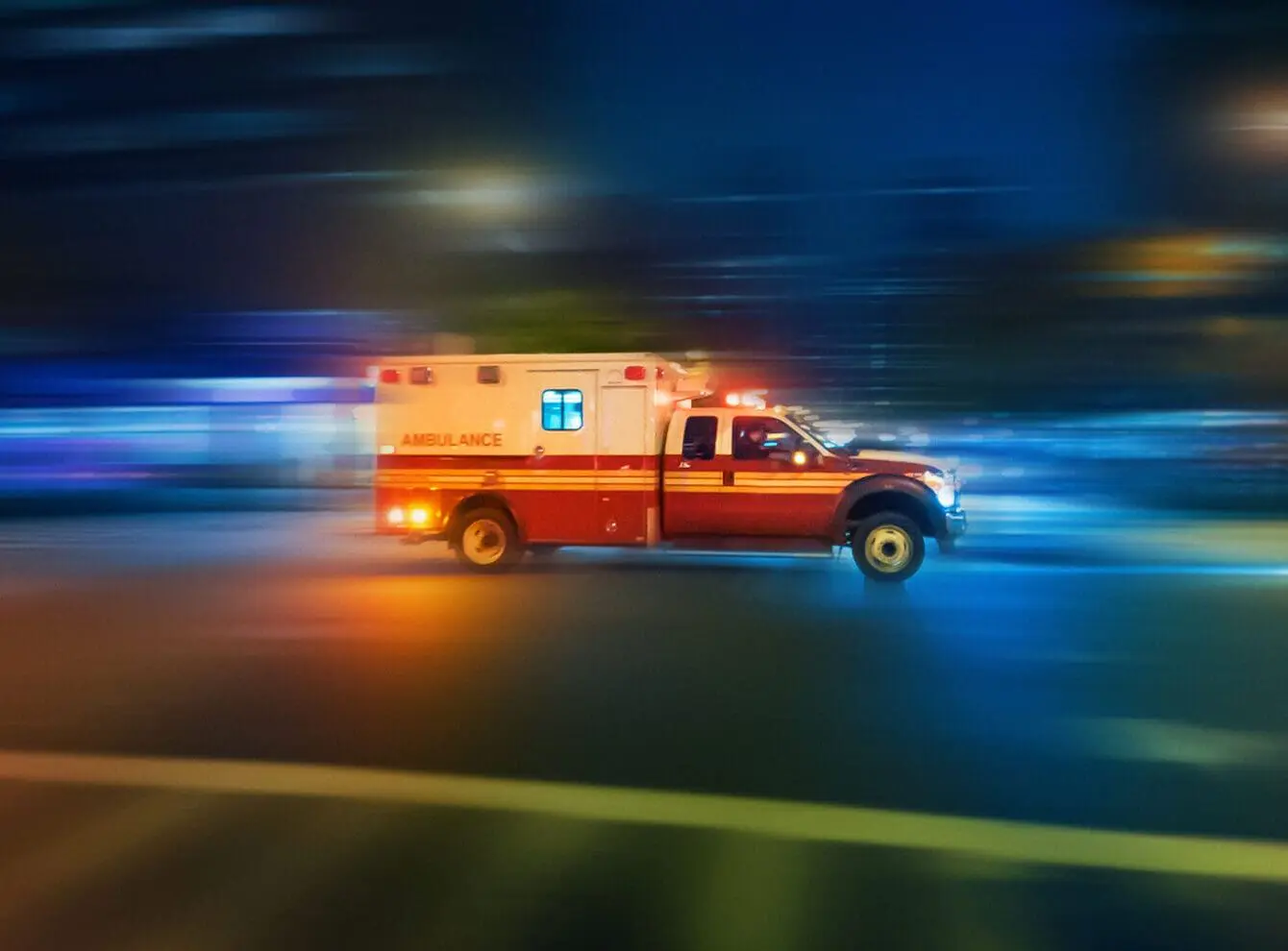 Ambulance racing in street at night